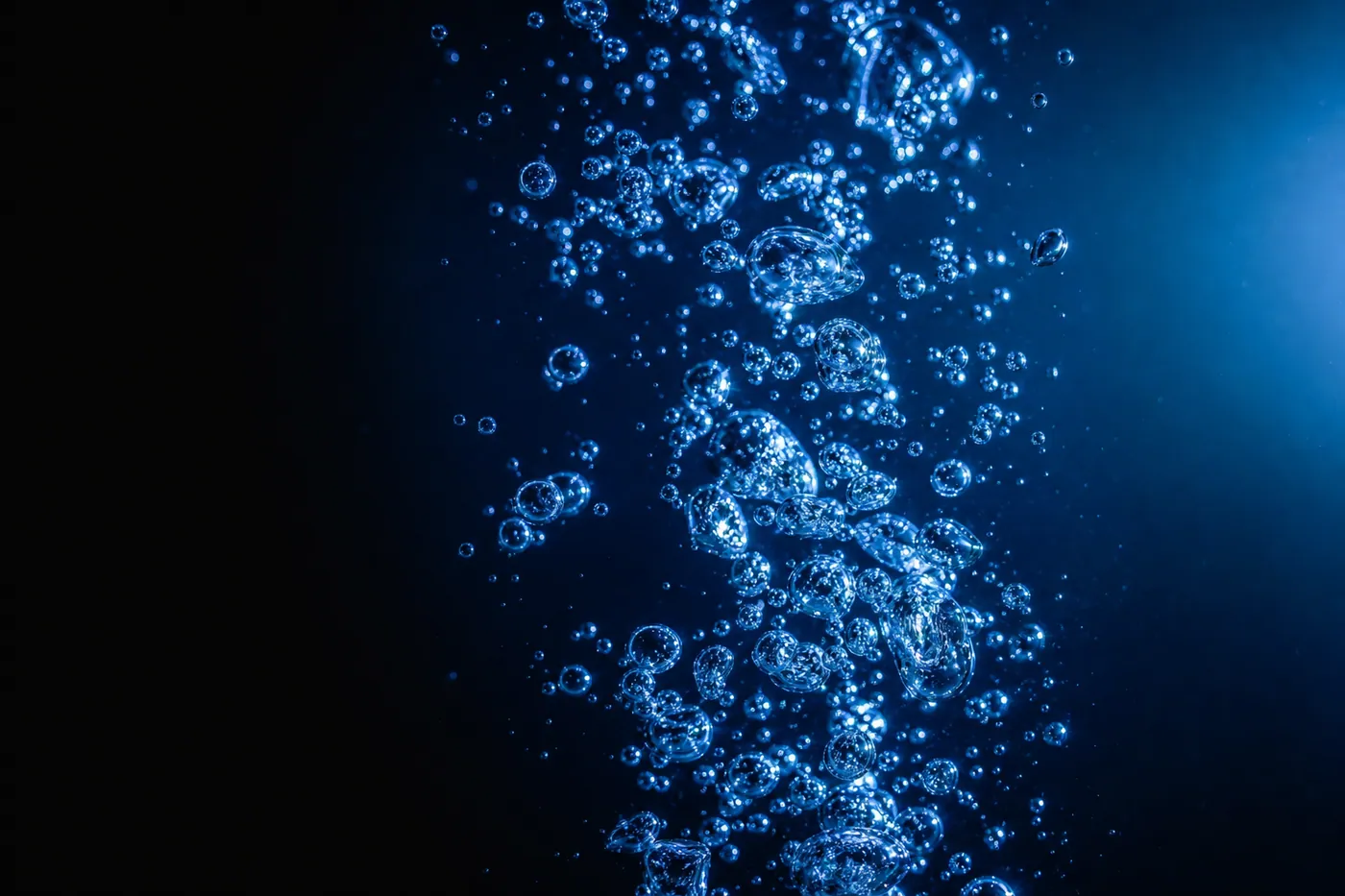 Microbubbles rising in clear blue water illustrating air-release technology